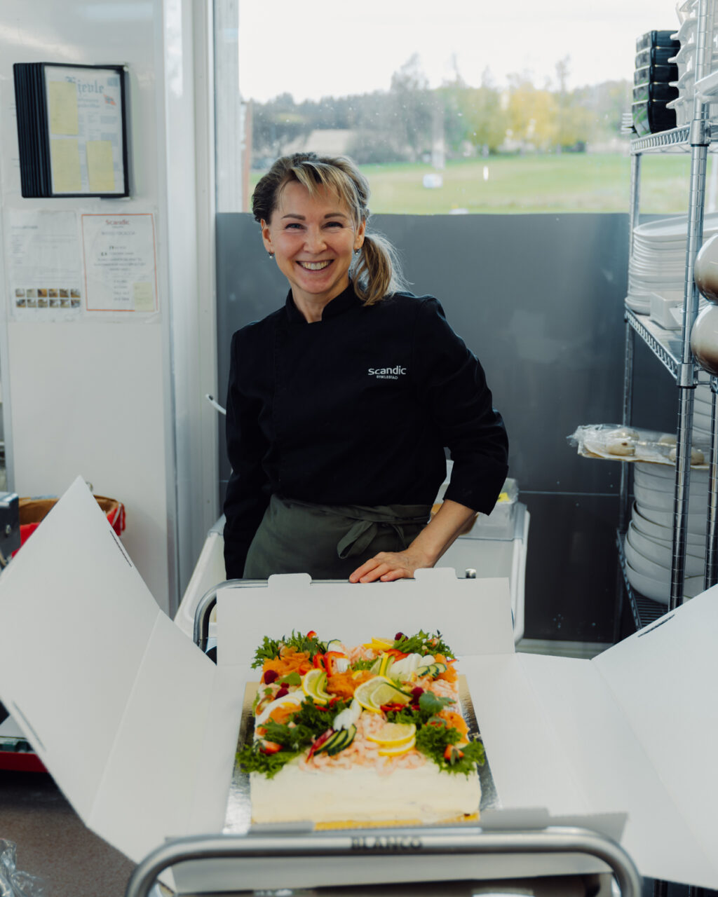 Kokk står klar med smørbrødkake for catering