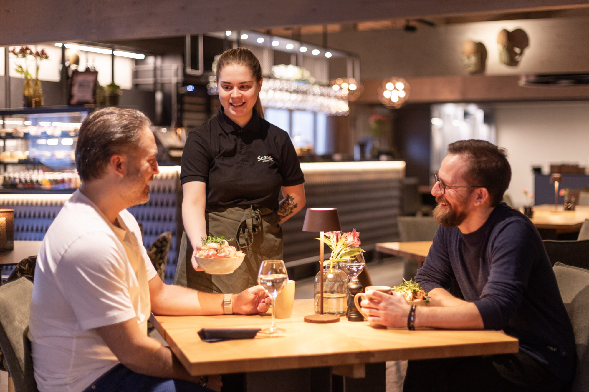 Bilde fra Restaurant Skalden med to personer som får servert mat av servitør